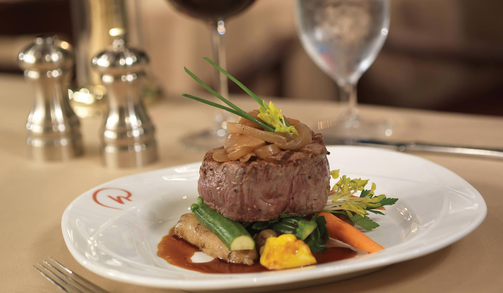 Delicious plate of steak on top of vegetables.